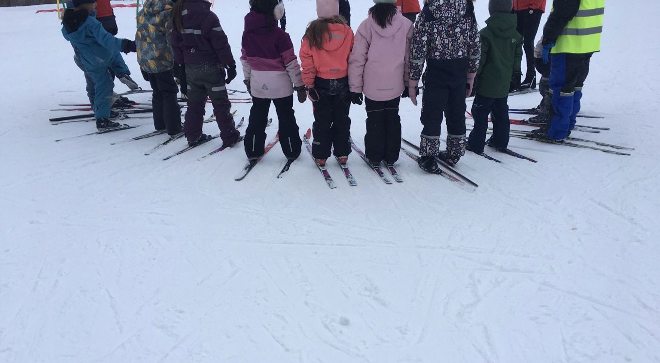 En gruppe mennesker som står på ski