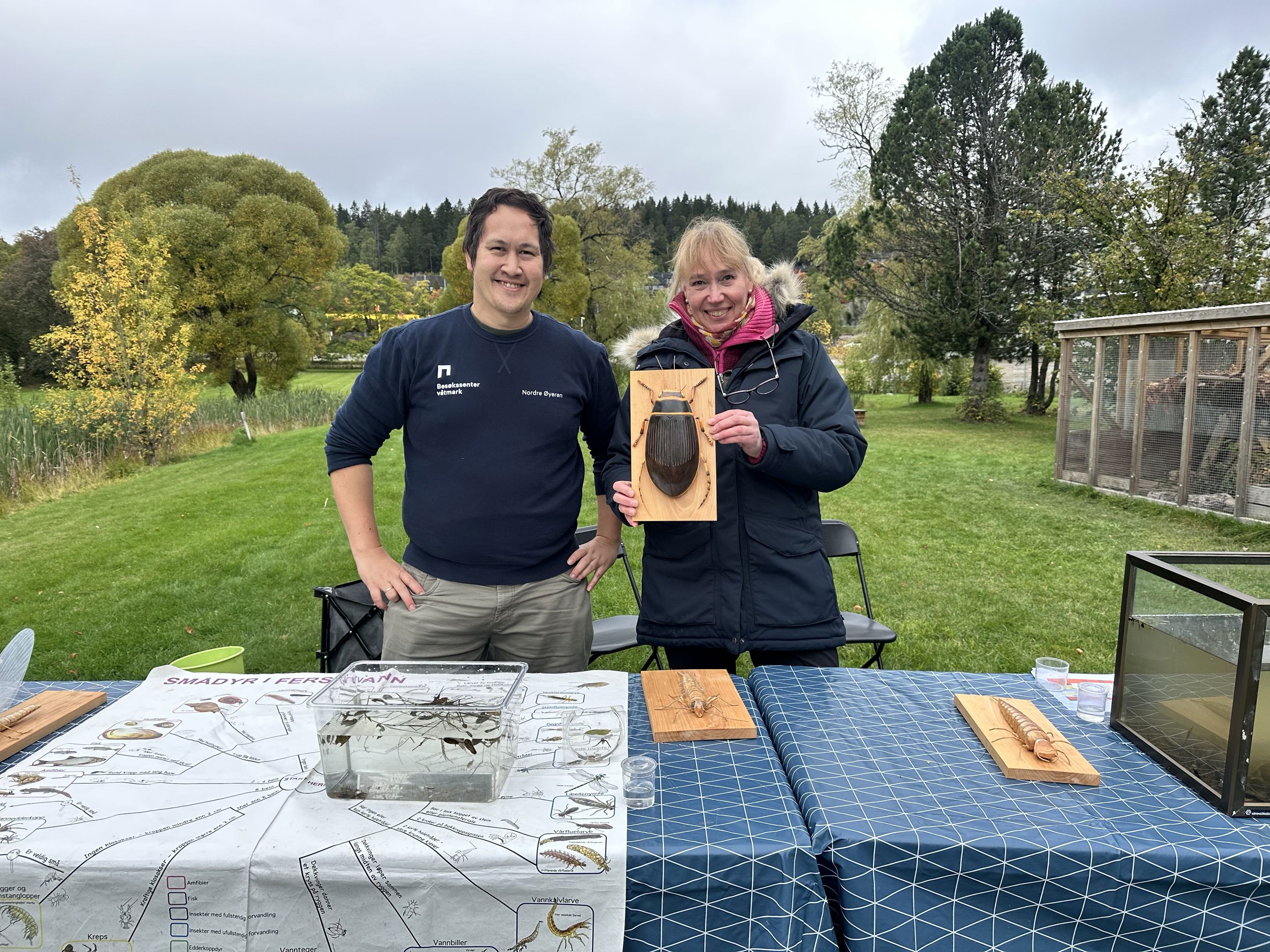 En person og en person står ved siden av et bord med en modell av et skip En person og en person står ved siden av et bord med en modell av et skip