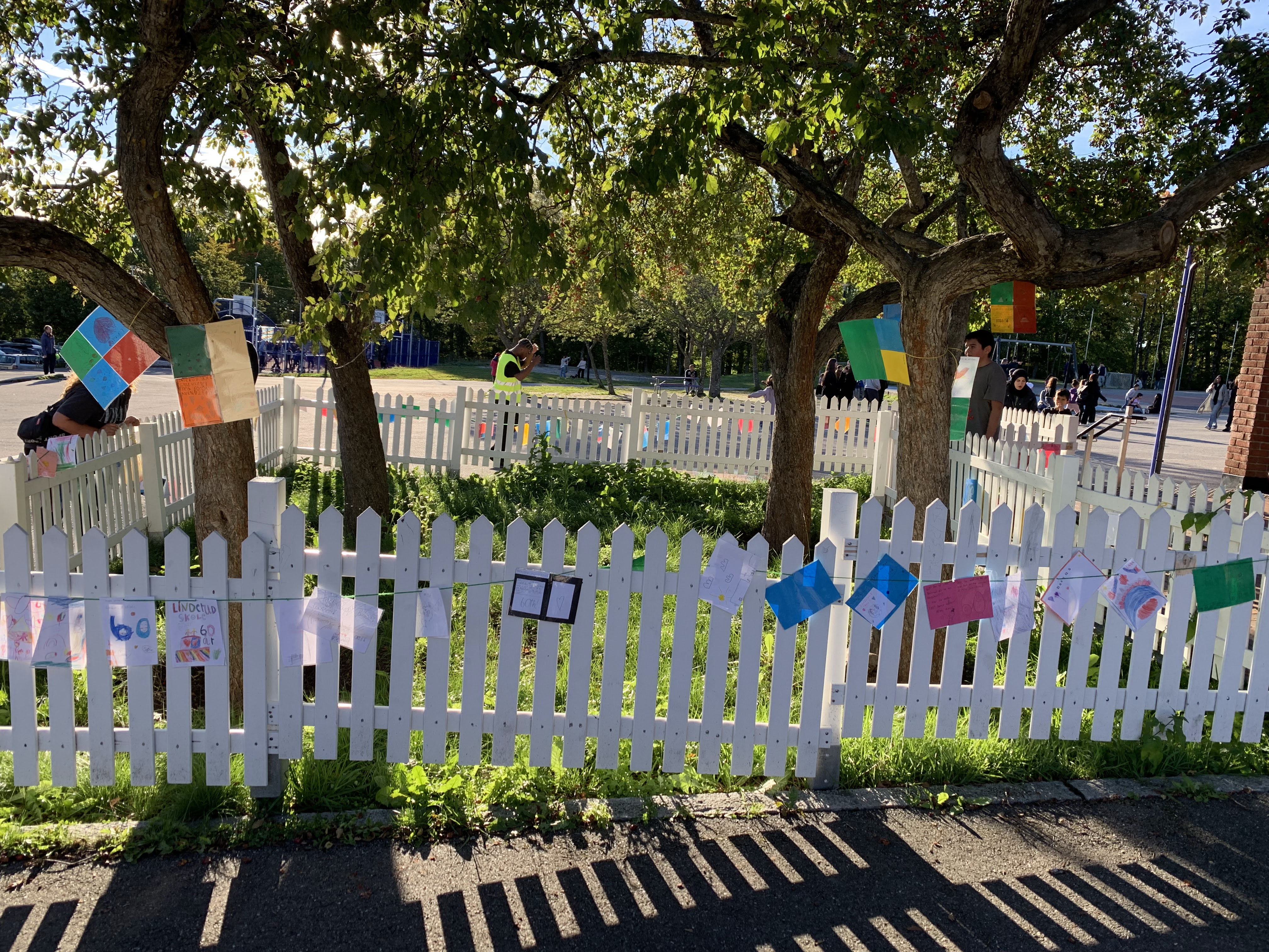 et hvitt stakittgjerde med flagg