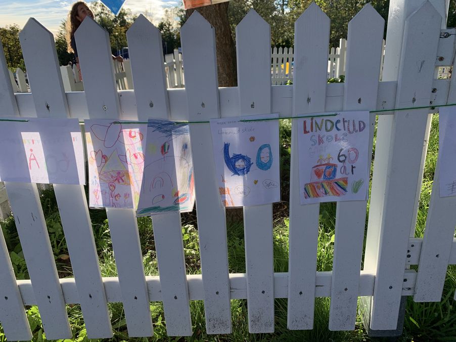 et hvitt stakittgjerde med et skilt på