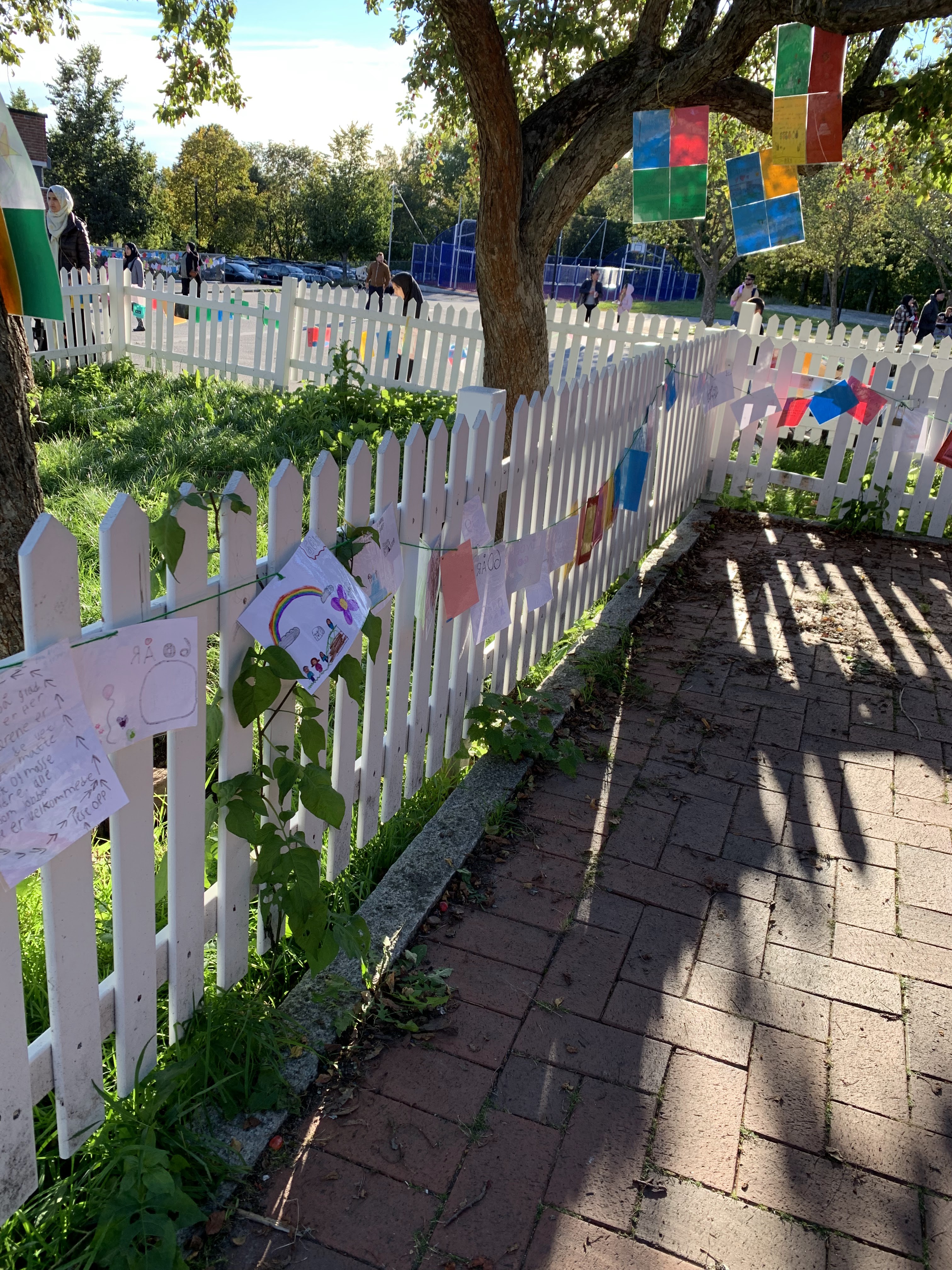 et hvitt stakittgjerde med røde og hvite blomster