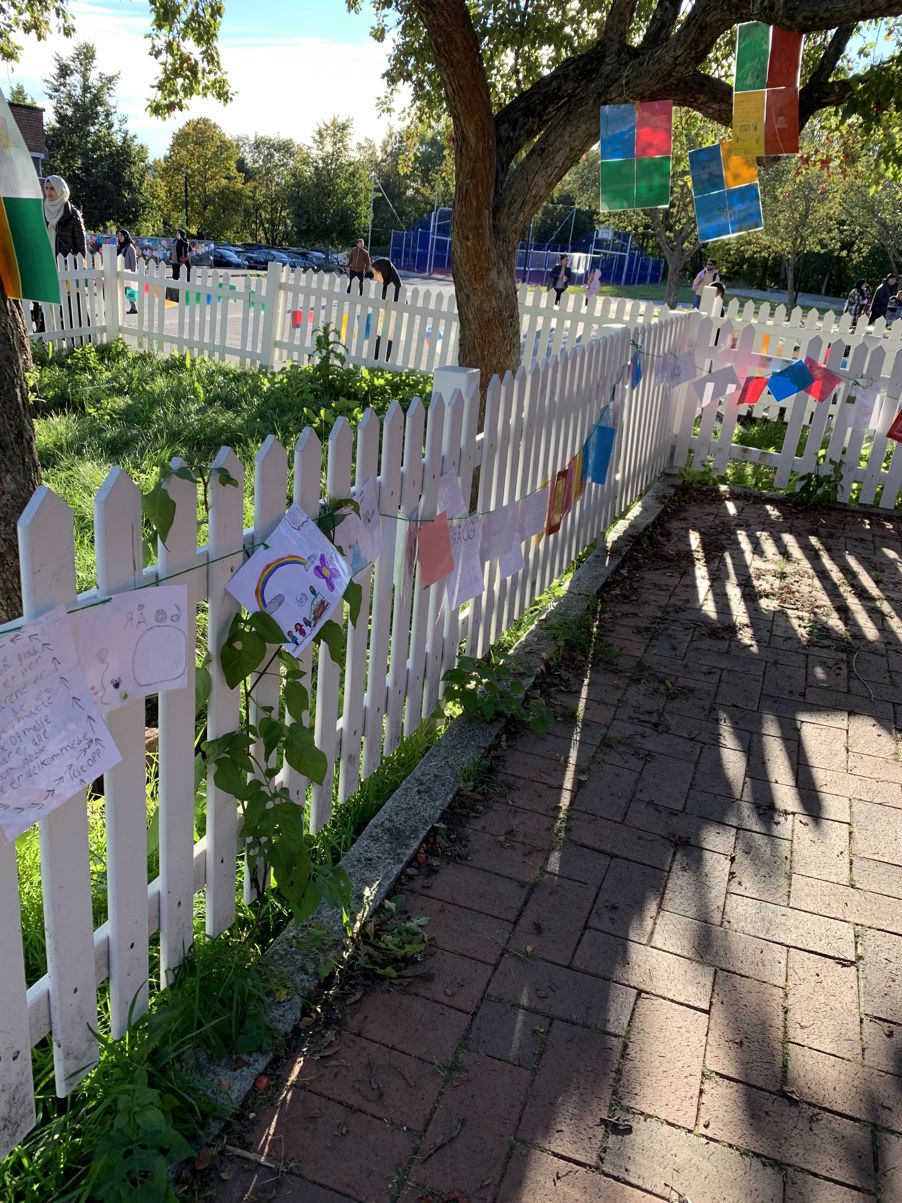 et hvitt stakittgjerde med røde og hvite blomster