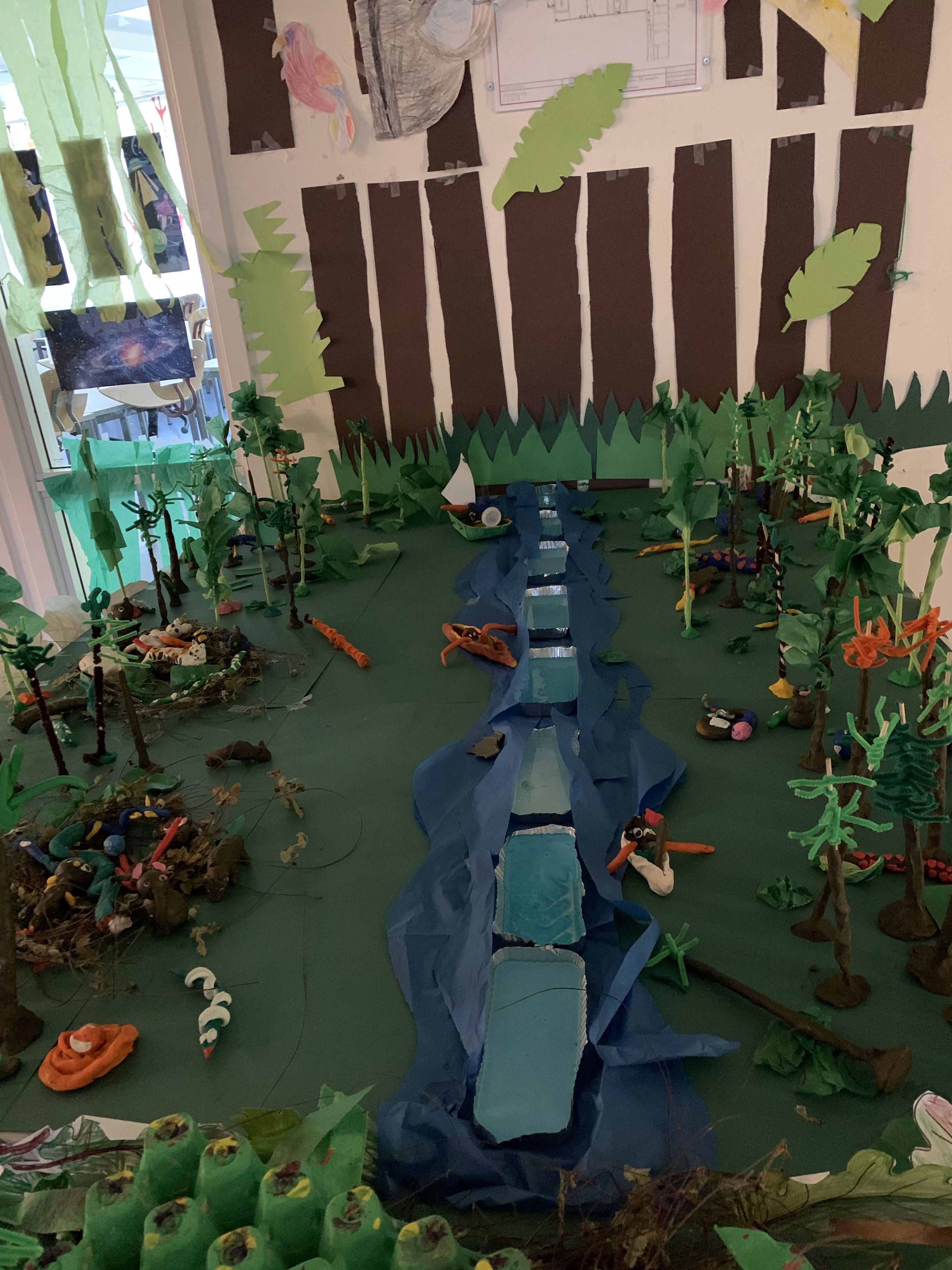 en statue av en person omgitt av planter og en vegg med et vindu