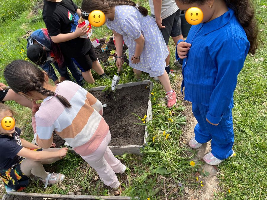 En gruppe barn som planter blomster