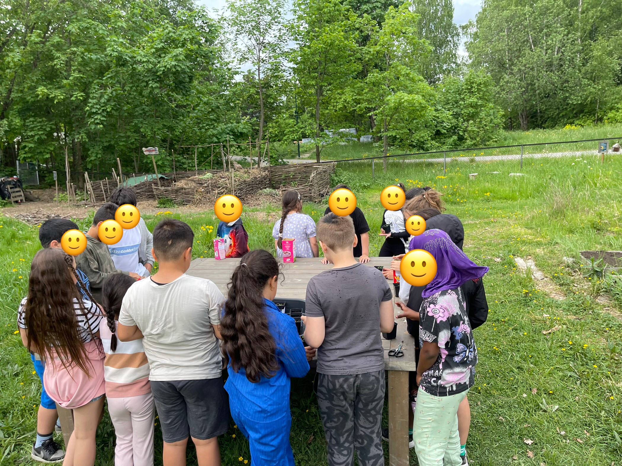 en gruppe mennesker som står rundt et gjerde med en gruppe mennesker i klær